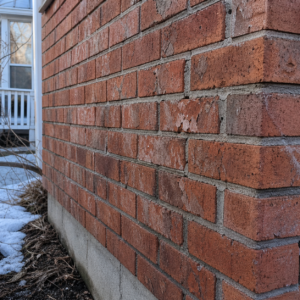Close-up of freeze-thaw damage in brick and mortar joints