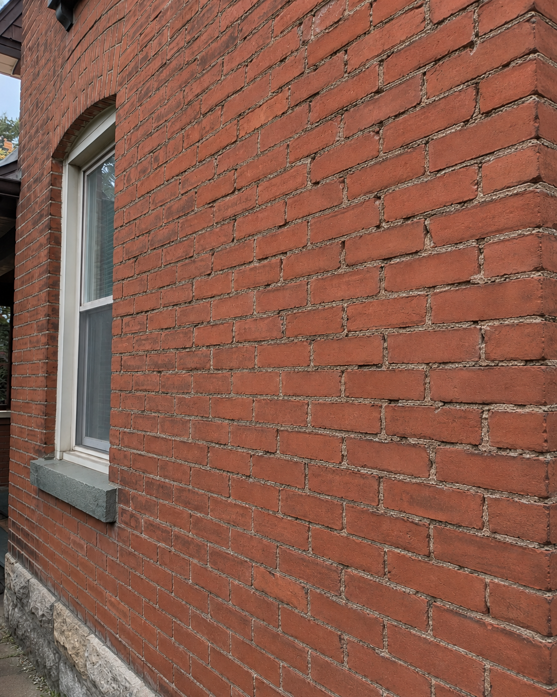 Large brick wall with worn mortar joints showing the need for full-wall repointing