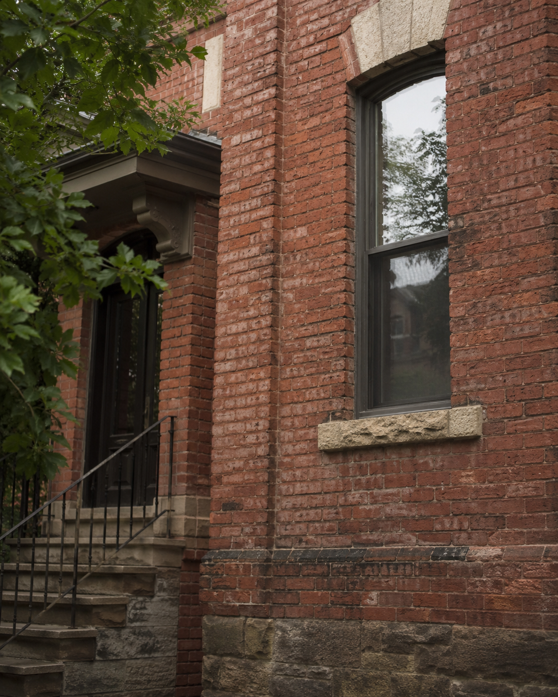 Weathered older Toronto brick facade with aged texture and visible masonry wear