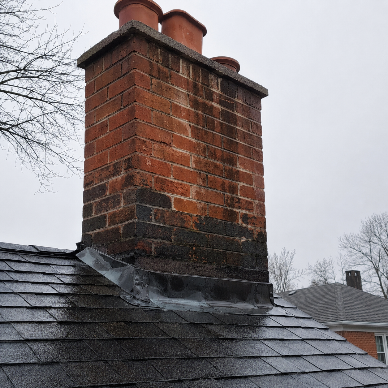 Water staining and leak signs around a brick chimney area.