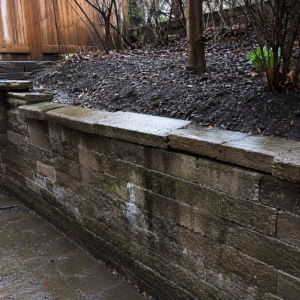 Masonry retaining wall with early signs of cracking and drainage stress.
