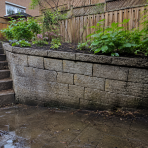 Leaning masonry retaining wall caused by pressure behind the wall.