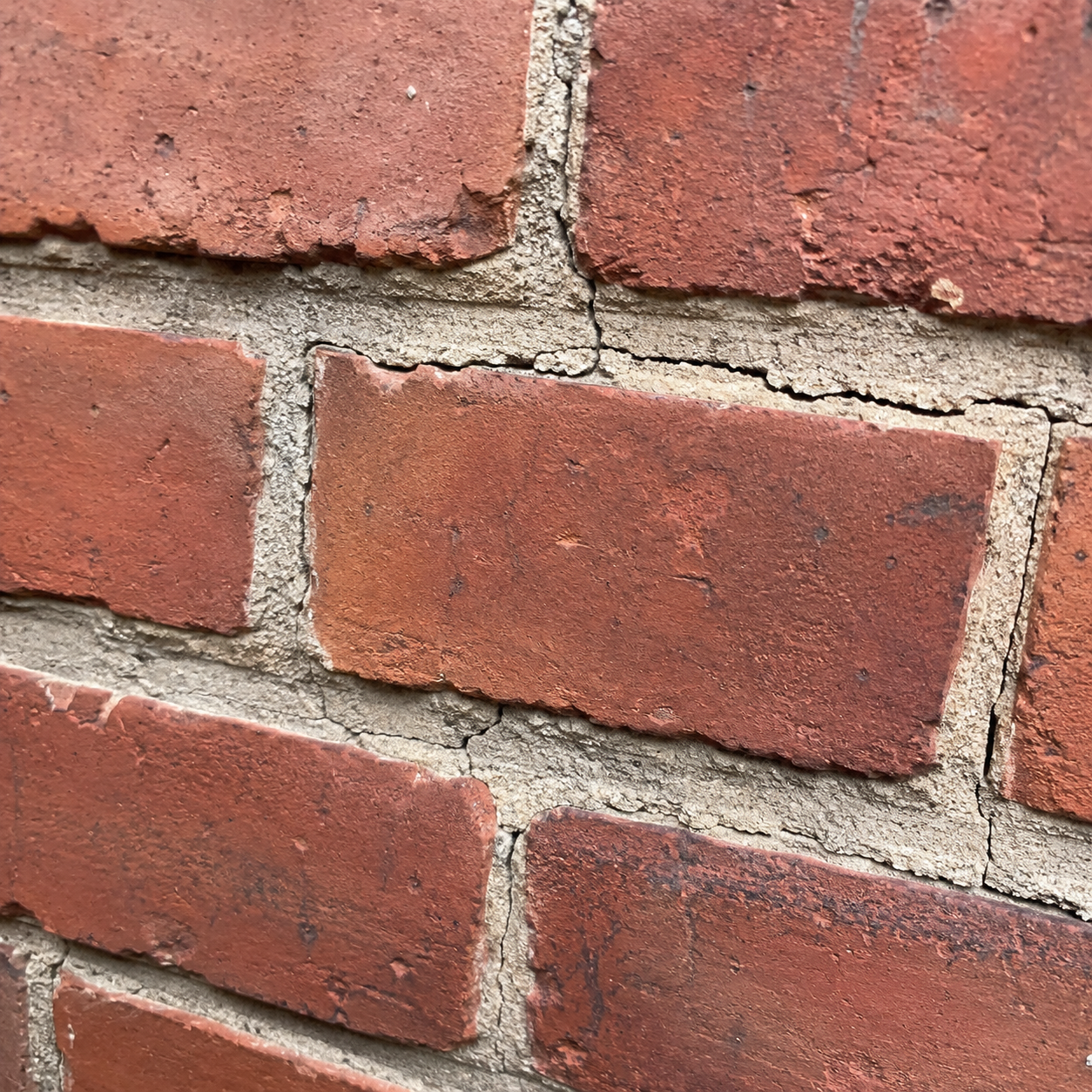 Cracked mortar joints between bricks on an older Toronto brick wall