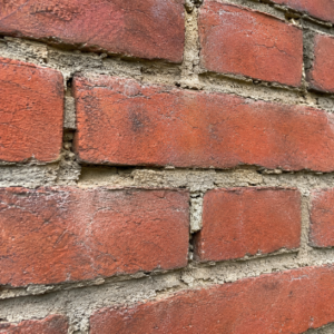 Failing mortar joints between red bricks on a Toronto home.